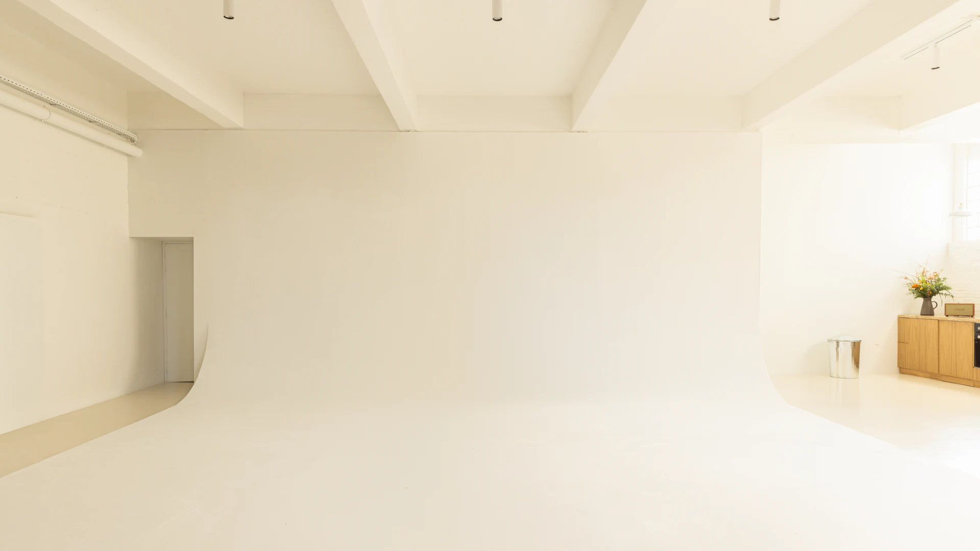 흰 벽과 곡면 바닥으로 이어진 넓고 밝은 호리존 스튜디오